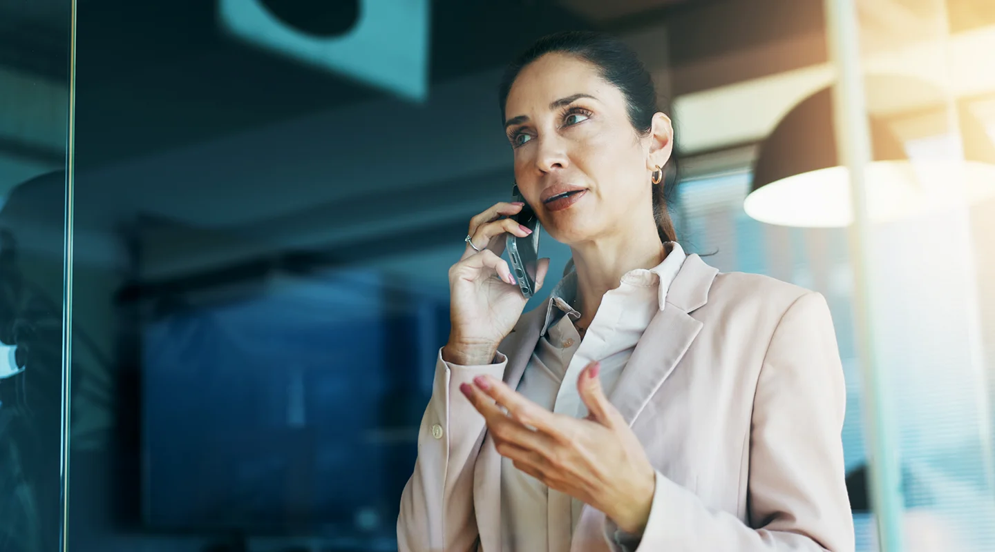 Imagem de uma mulher executiva falando no celular